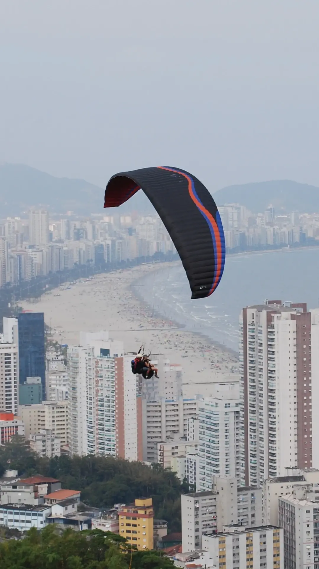 Voo duplo de parapente, paraglider e asa delta sobre a Baixada Santista